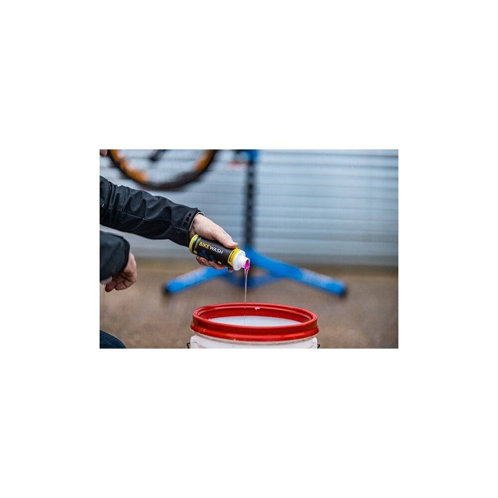 Gtechniq Bike Wash 250ml bottle, biodegradable pH-neutral cleaner for bikes, with workshop background and bike parts visible