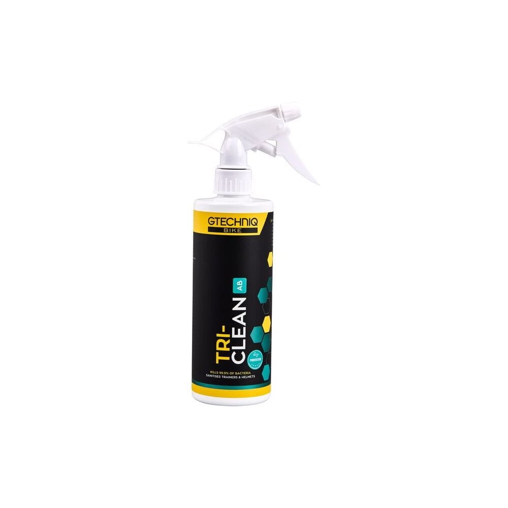 Gtechniq Bike Tri-Clean antibacterial cleaner for cycling gear and helmets, shown in a workshop setting.