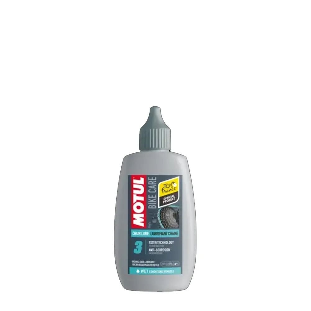 Motul Chain Lube Wet 100ml for bikes, showing the lubricant bottle with a bike chain in the workshop setting
