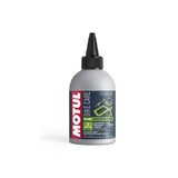 Motul EZ Lube 300ml spray lubricant for rust prevention and smooth operation, shown in a workshop setting.