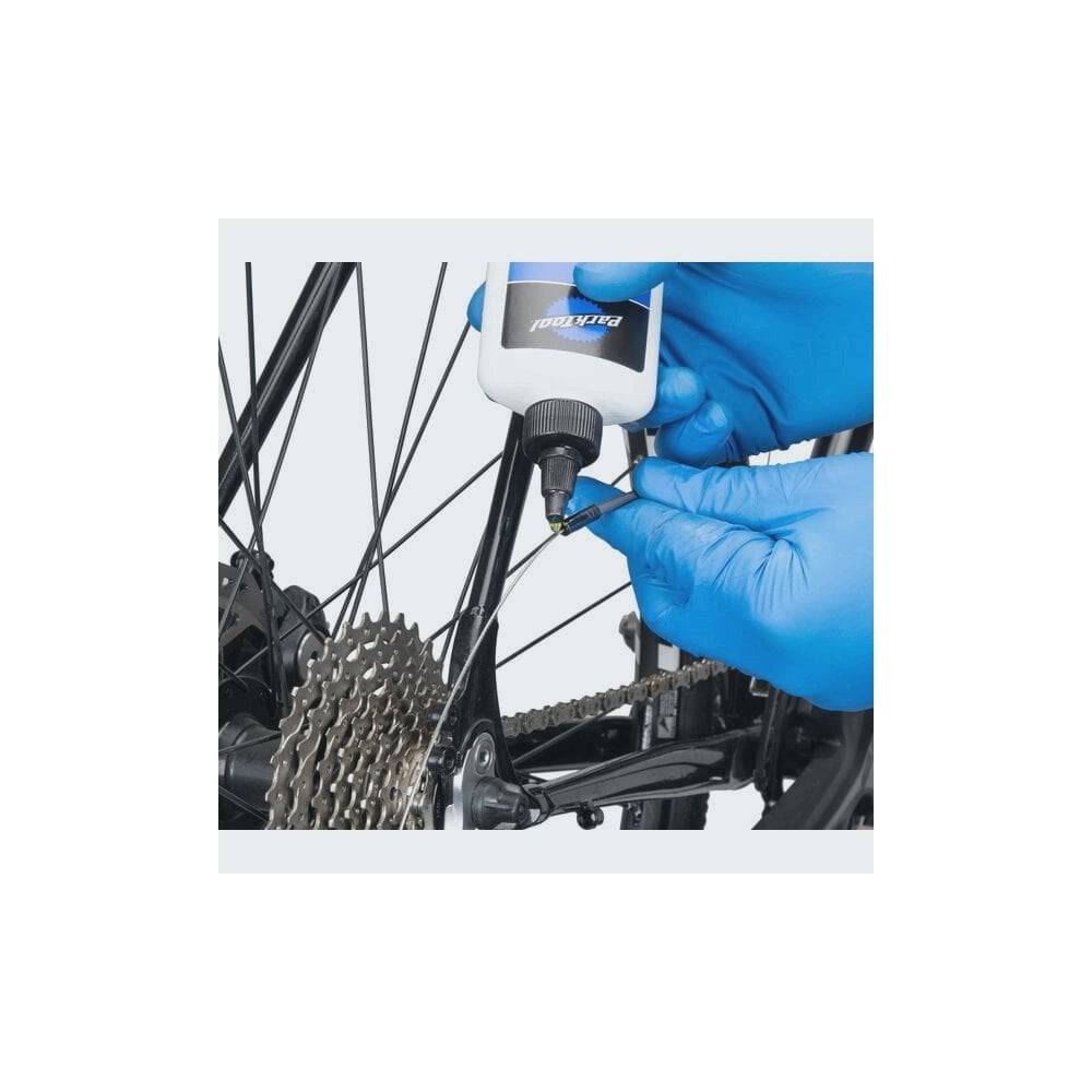 Park Tool CL-1.2 synthetic bike chain lube in a workshop setting, eco-friendly lubricant for smooth, durable bike chain performance.