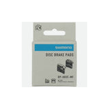 Shimano H03C-MF metal sintered disc brake pads with spring and cooling fins for 4-piston mountain bike brake systems.