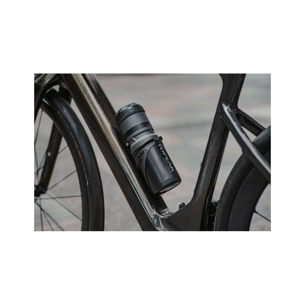 Topeak Escape Pod+ bike storage bag in black, mounted in a standard bottle cage for carrying tools and small accessories.