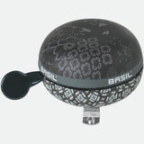 Basil Bohème 80mm charcoal bicycle bell with a stylish design and loud sound, mounted on a bike handlebar.