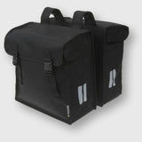 Basil Mara XXL black double bike bag with water-repellent material and reflective strips, mounted on a bicycle pannier rack.