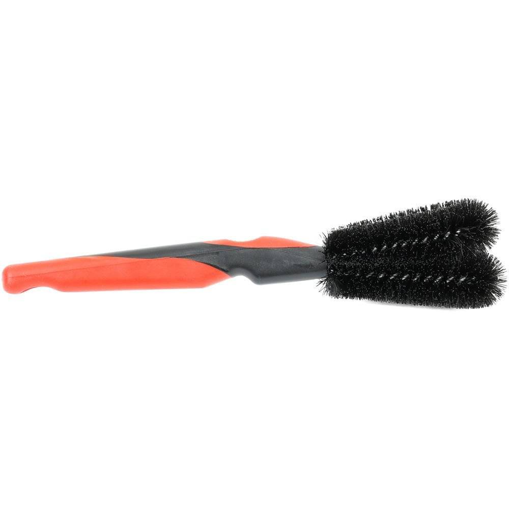 Zefal ZB Twist Brush bike cleaning tool with adjustable double-head for cleaning pedals and disc brakes in a workshop setting.