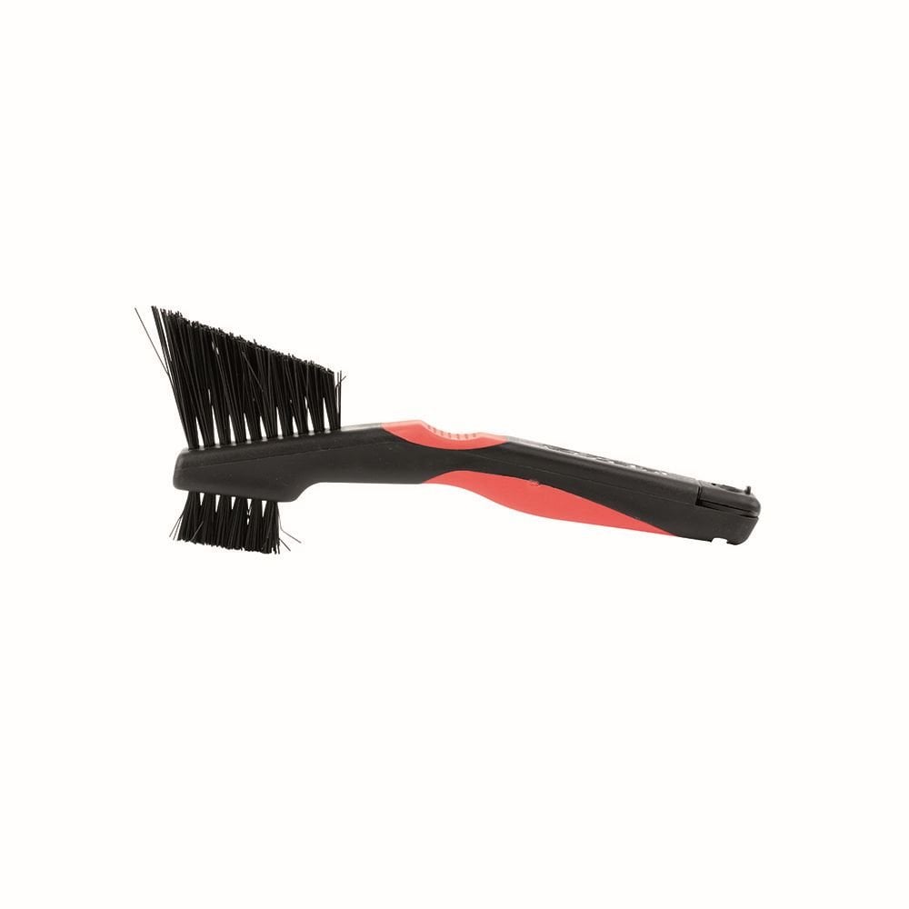 Zefal Clean Brush 3-in-1 bike cleaning tool for chain, freewheel, and derailleur, shown in a workshop setting.