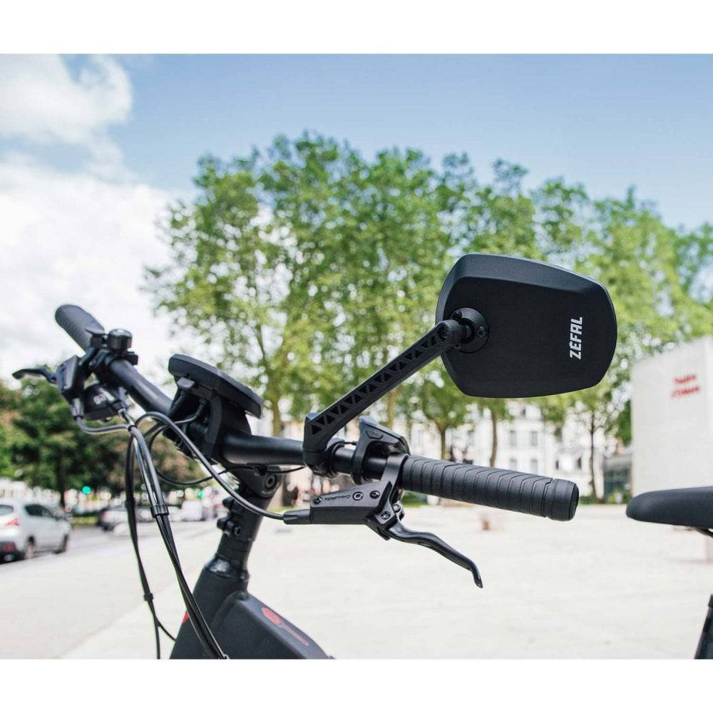 Zefal Espion E80 bike mirror with adjustable handlebar mount on a bicycle handlebar for rearview visibility.