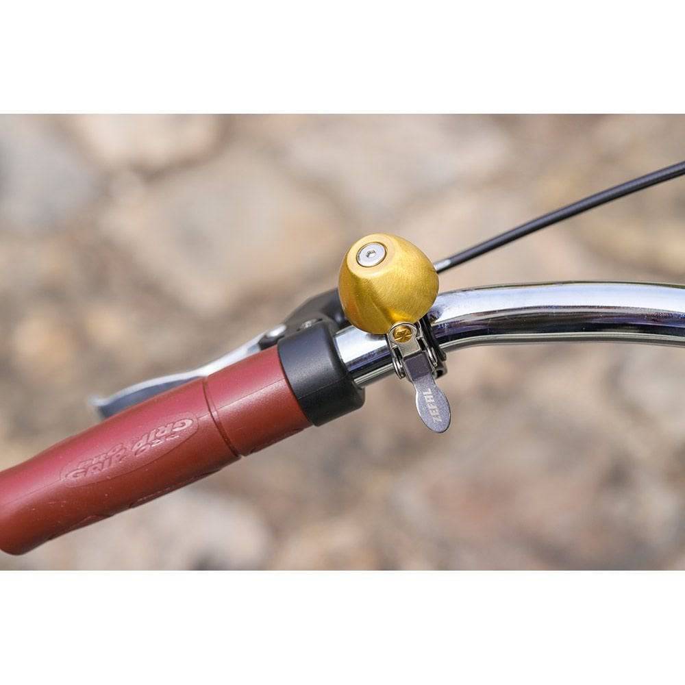 Zefal Classic Brass Bike Bell with a loud ring and easy installation, mounted on a bicycle handlebar for bike accessories.