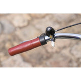 Zefal Classic Brass Bike Bell with horns, mounted on a bike handlebar, featuring a shiny polished finish and easy installation.