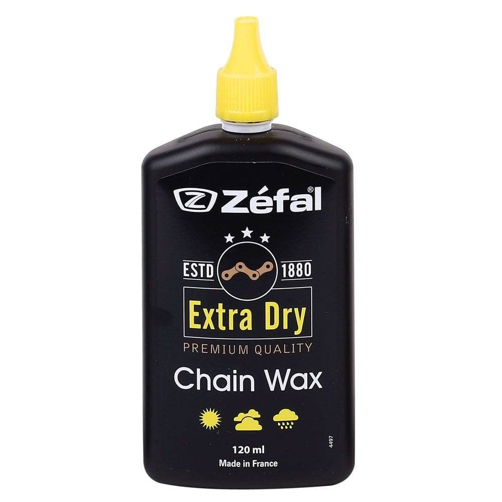 Zefal Extra Dry Chain Wax lubricant bottle for bike drivetrain protection and smooth gear shifting, workshop setting.