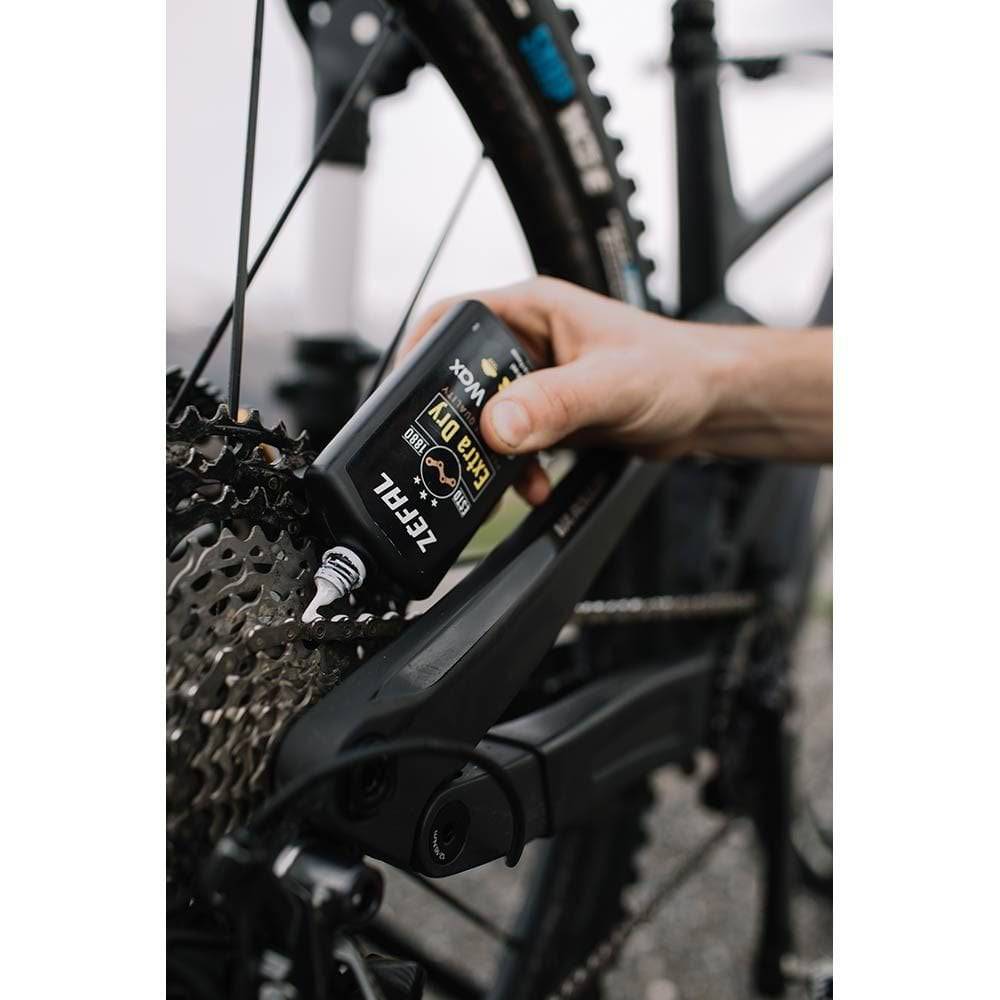 Zefal Extra Dry Chain Wax lubricant applied to bike chain, protecting drivetrain and ensuring smooth gear shifts.