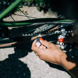 Zefal Extra Wet Ceramic bike chain lubricant bottle for all weather conditions, shown in a workshop setting.
