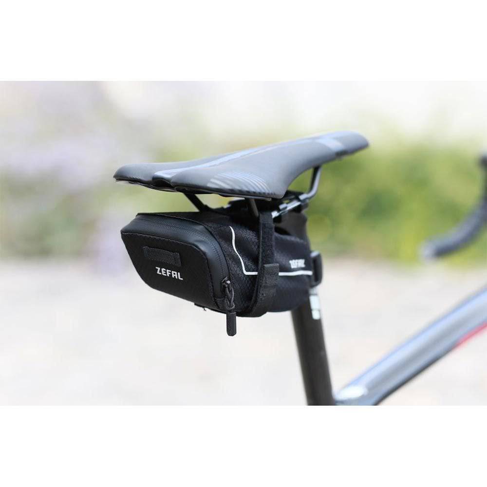 Zefal Z Light Saddle Pack with reflective stripes and light mount attached to a bike seat for storage and visibility.