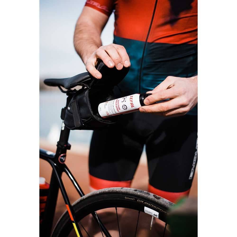 Zefal puncture repair spray in workshop setting, used for quick flat tire fixes and re-inflation on bikes.
