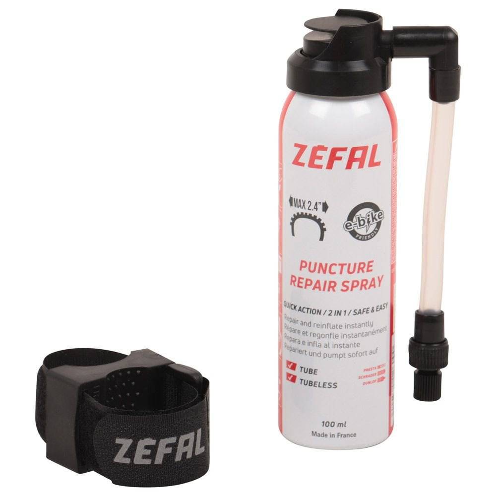 Zefal puncture repair spray for bikes, showing a workshop setting with spray can used for quick flat tire fixes and re-inflation.