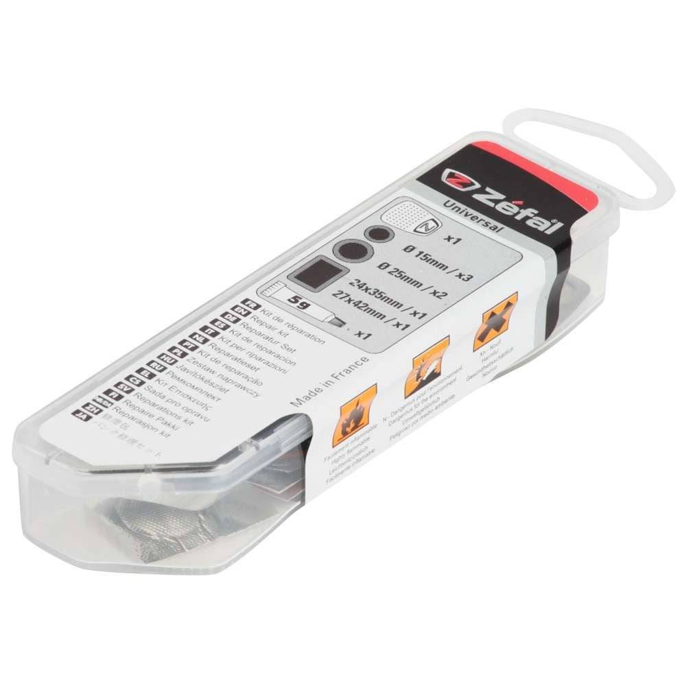 Zefal Universal Puncture Repair Kit for bikes with patches, cement, and grater, displayed on a workshop table.