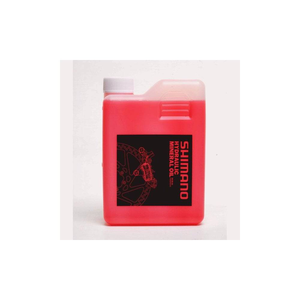 Shimano Mineral Oil Hydraulic Brake Fluid 1 Litre in red for disc brakes, shown in a workshop setting