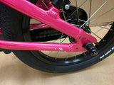 Pink Ridgeback Kids Dimension 14-inch beginner bike with training wheels, ideal for young children learning to ride.