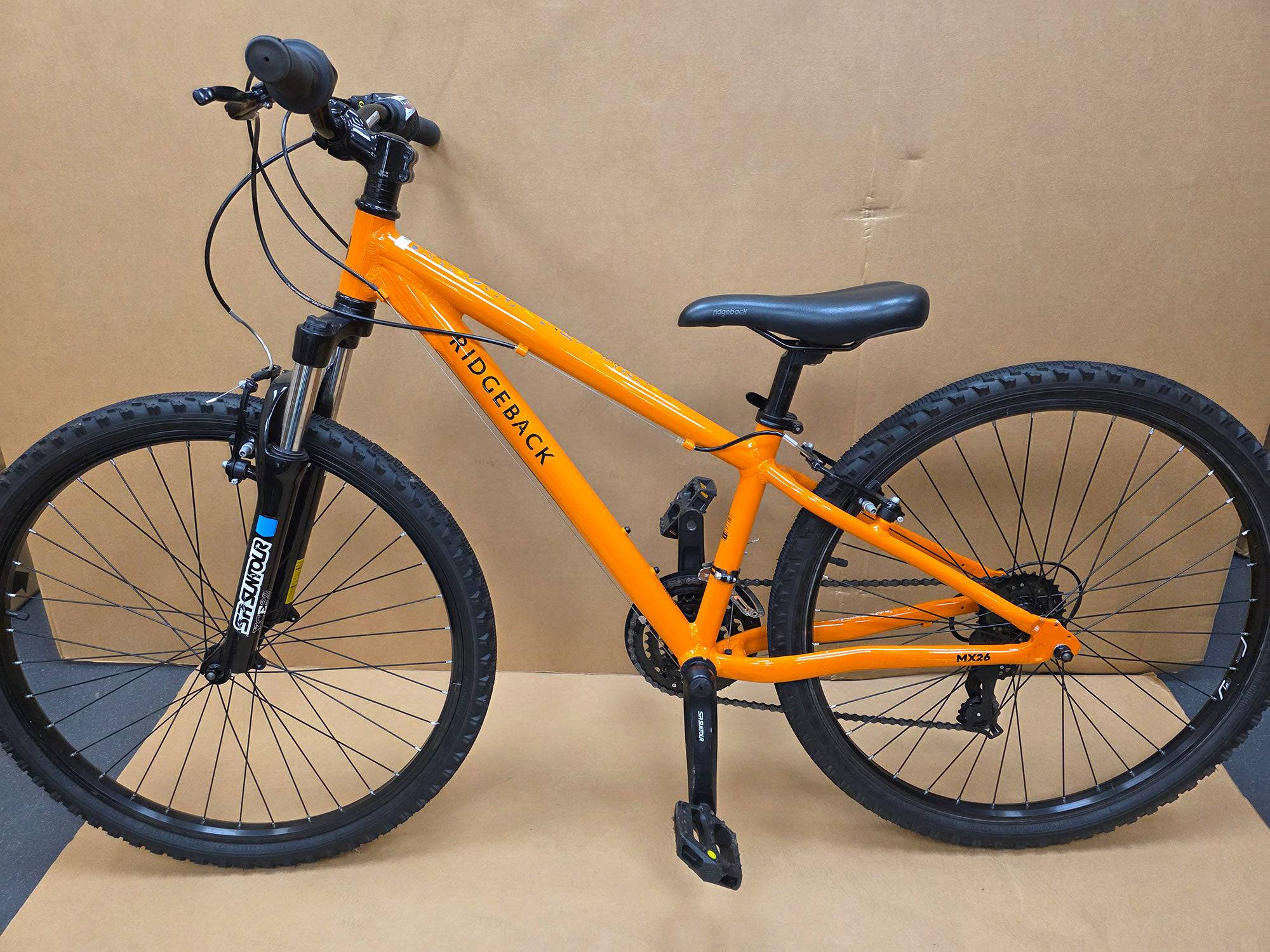 Ridgeback Kids MX26 26-inch children's bike with sturdy frame and colorful design, suitable for young riders outdoors.