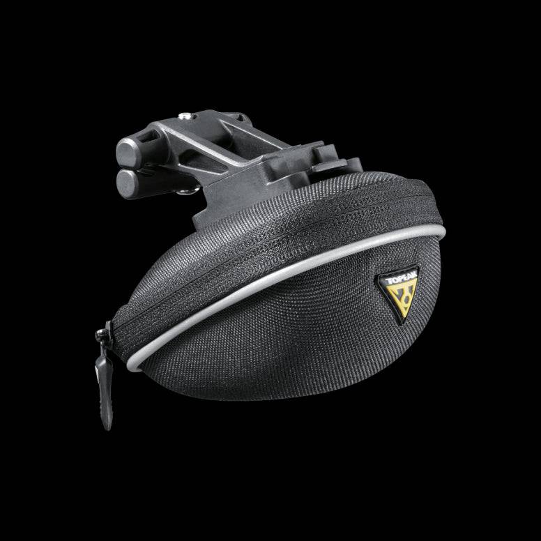 Topeak Propack lightweight bike seat pack with quick release strap and reflective piping, mounted on a bike saddle.
