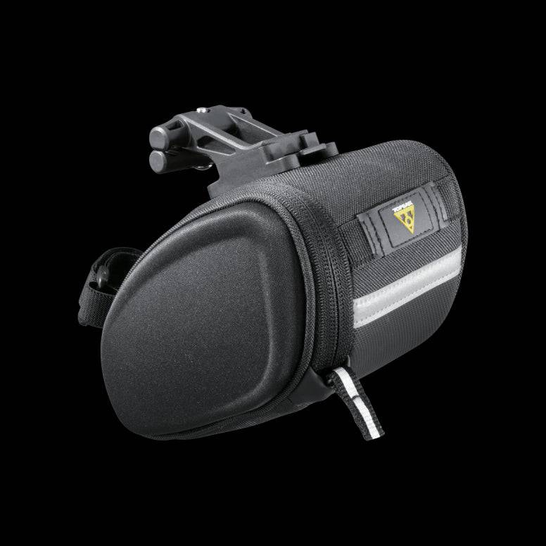 Topeak Sidekick Wedge Pack bike seat bag with semi-rigid design and reflective strip, mounted on bicycle saddle.