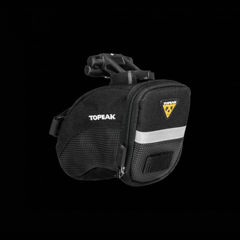Topeak Aero Wedge Quickclick bike seat pack with pump holder and reflective strip attached to a bicycle seat.