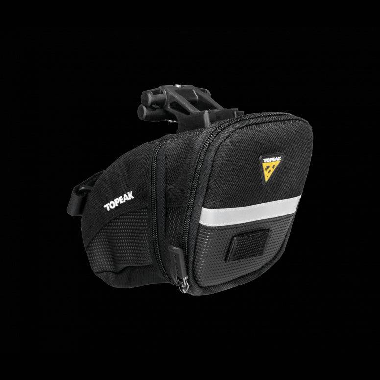 Topeak Aero Wedge Quickclick bike seat pack with pump holder and reflective strip, mounted on a bicycle seat for gear storage
