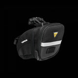 Topeak Aero Wedge Quickclick bike seat pack with pump holder and reflective strip, mounted on a bicycle seat for gear storage