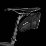 Topeak Aero Wedge Quickclick bike seat pack with pump holder and reflective strip, mounted on bike saddle for storage.