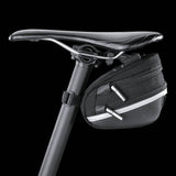 Topeak Wedge II Black Micro Bike Seat Pack with quick release mount and reflective strips attached to a bicycle saddle.