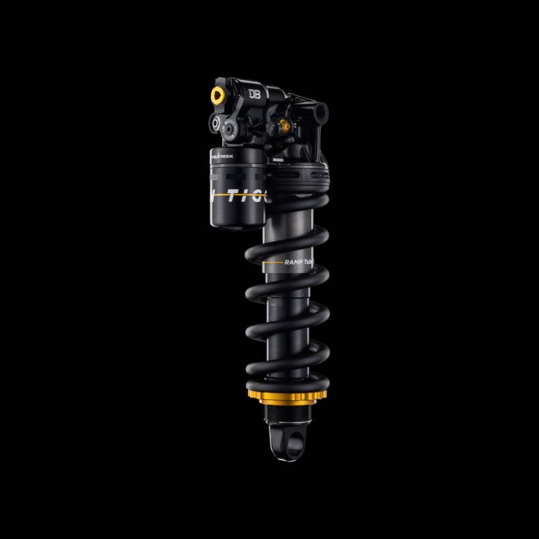 Cane Creek Tigon Coil trunnion rear shock with air-charged coil and RAMP tube technology for mountain bike suspension.
