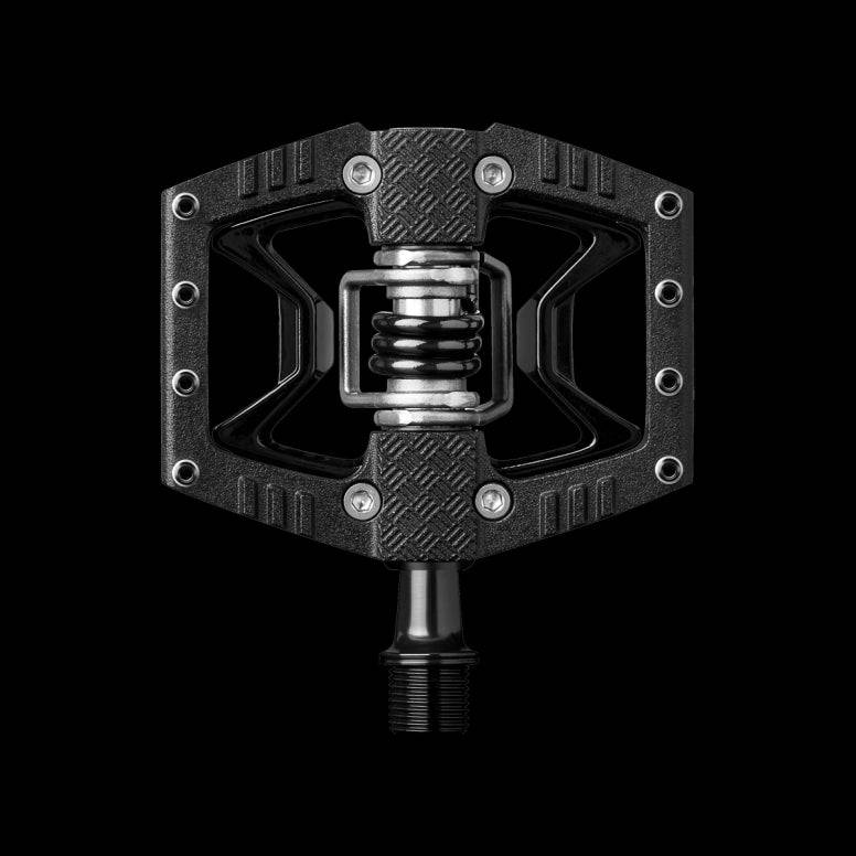 Crank Brothers Double Shot 3 hybrid clipless and flat pedal with adjustable cleats, shown from a side view on a bike component.