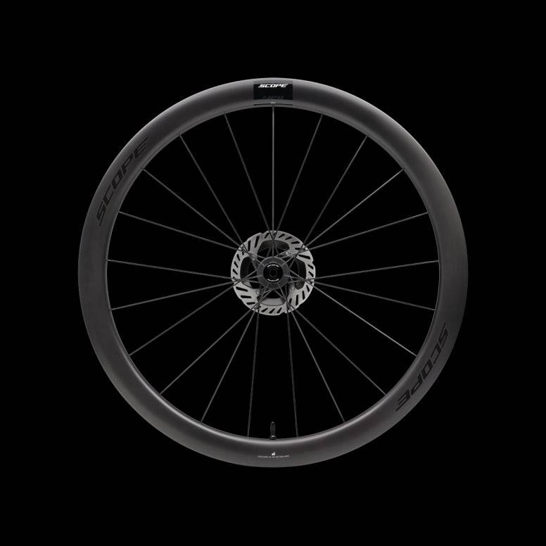 Scope Cycling R4.A V2 45mm allroad wheelset with tubeless-ready, aerodynamic design, shown on a bike component background.