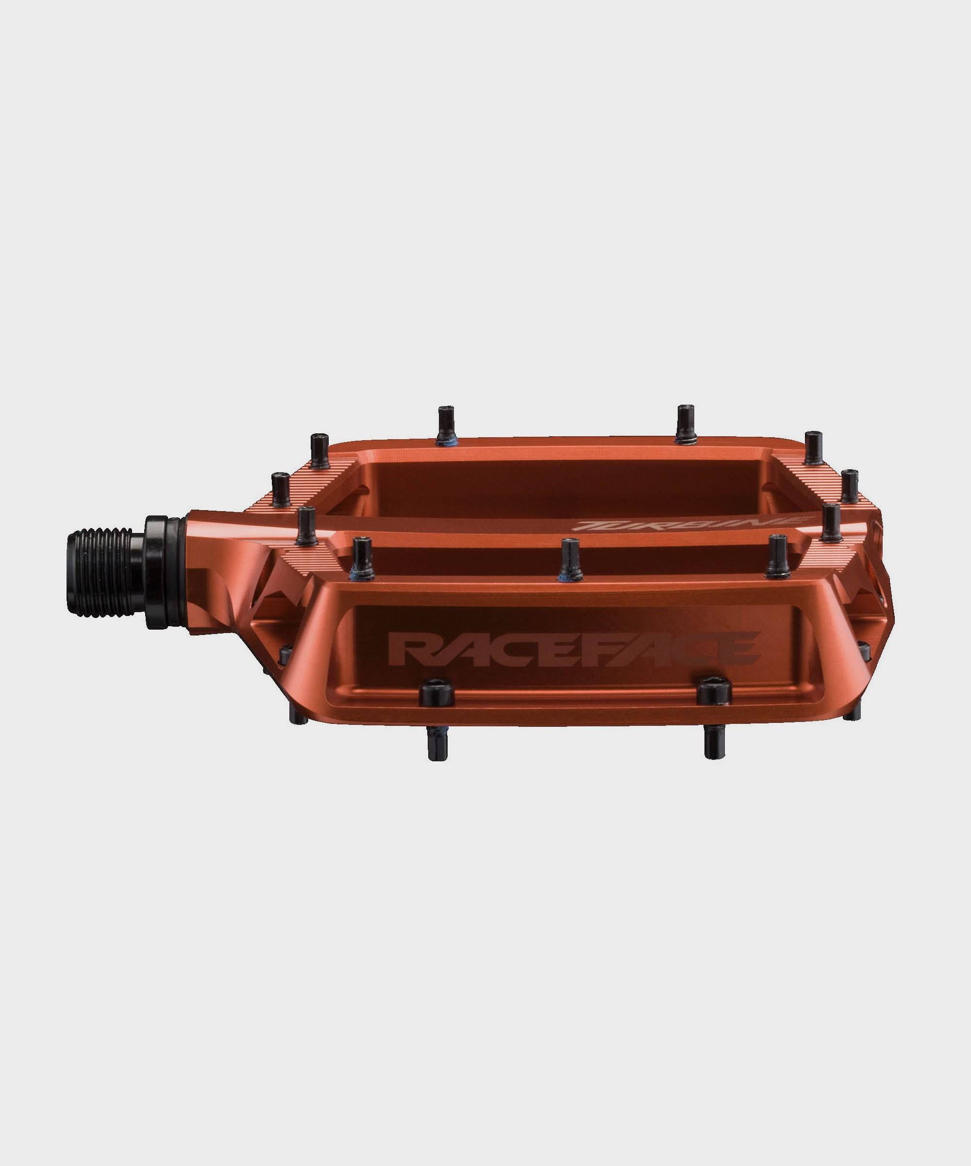 Race Face Turbine mountain bike pedals with adjustable pins for enhanced grip and durability, shown with cleats attached.