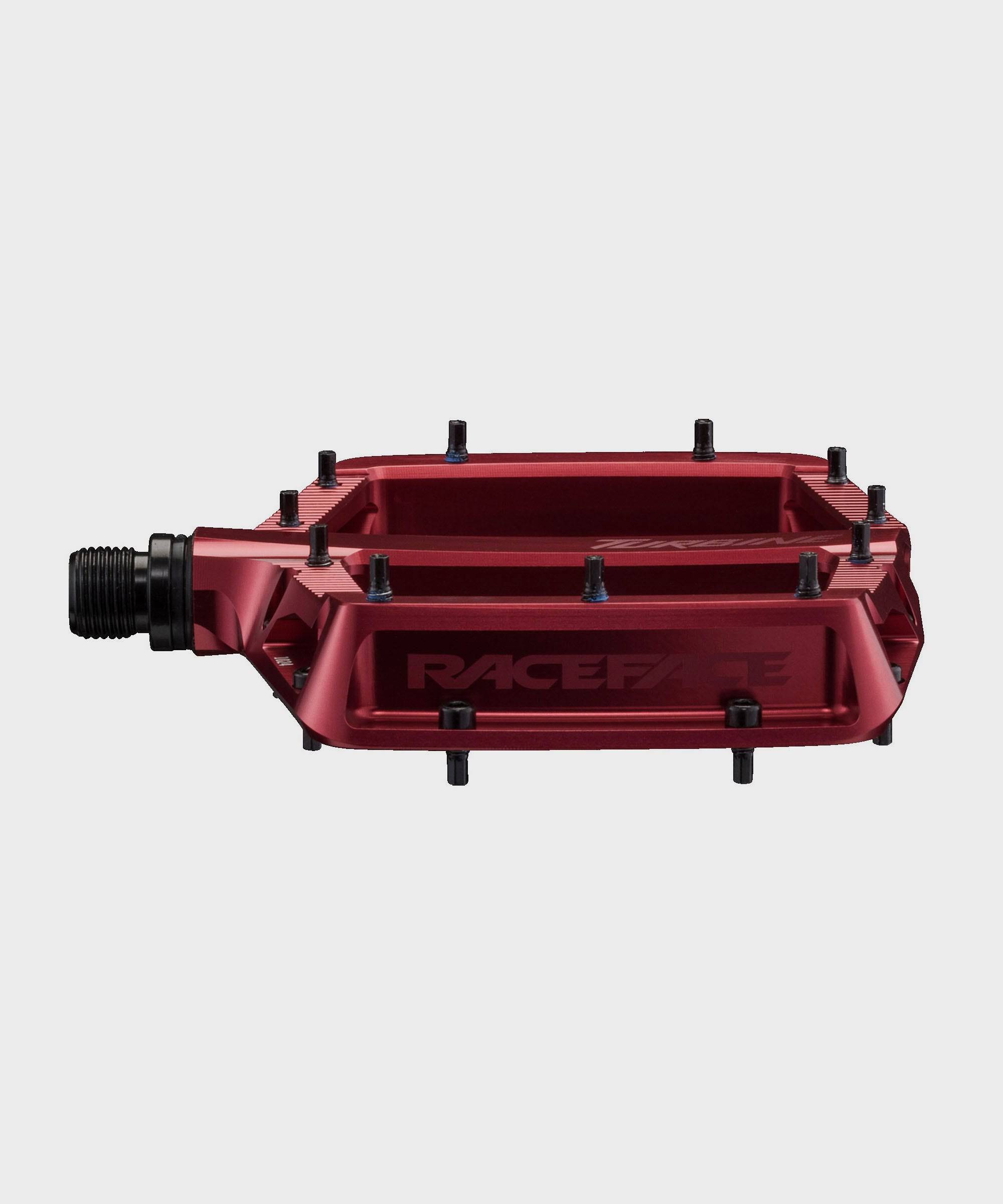 Race Face Turbine mountain bike pedals with adjustable pins for maximum grip, showcasing durable metal construction and grip-enhancing design.