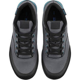 Shimano GF4W women's gravel cycling shoes with flat pedals and ULTREAD grip, shown in a natural outdoor setting.