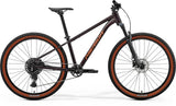 Merida Big Seven 40 MY26 aluminium hardtail mountain bike with Shimano drivetrain, black and red frame, outdoor riding scene