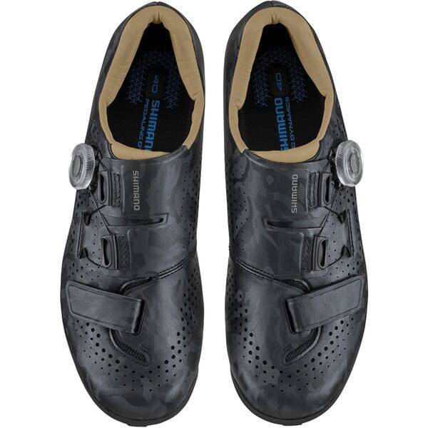 Shimano RX6W women's gravel cycling shoes with BOA dial and TPU lugs, shown in a natural outdoor setting.