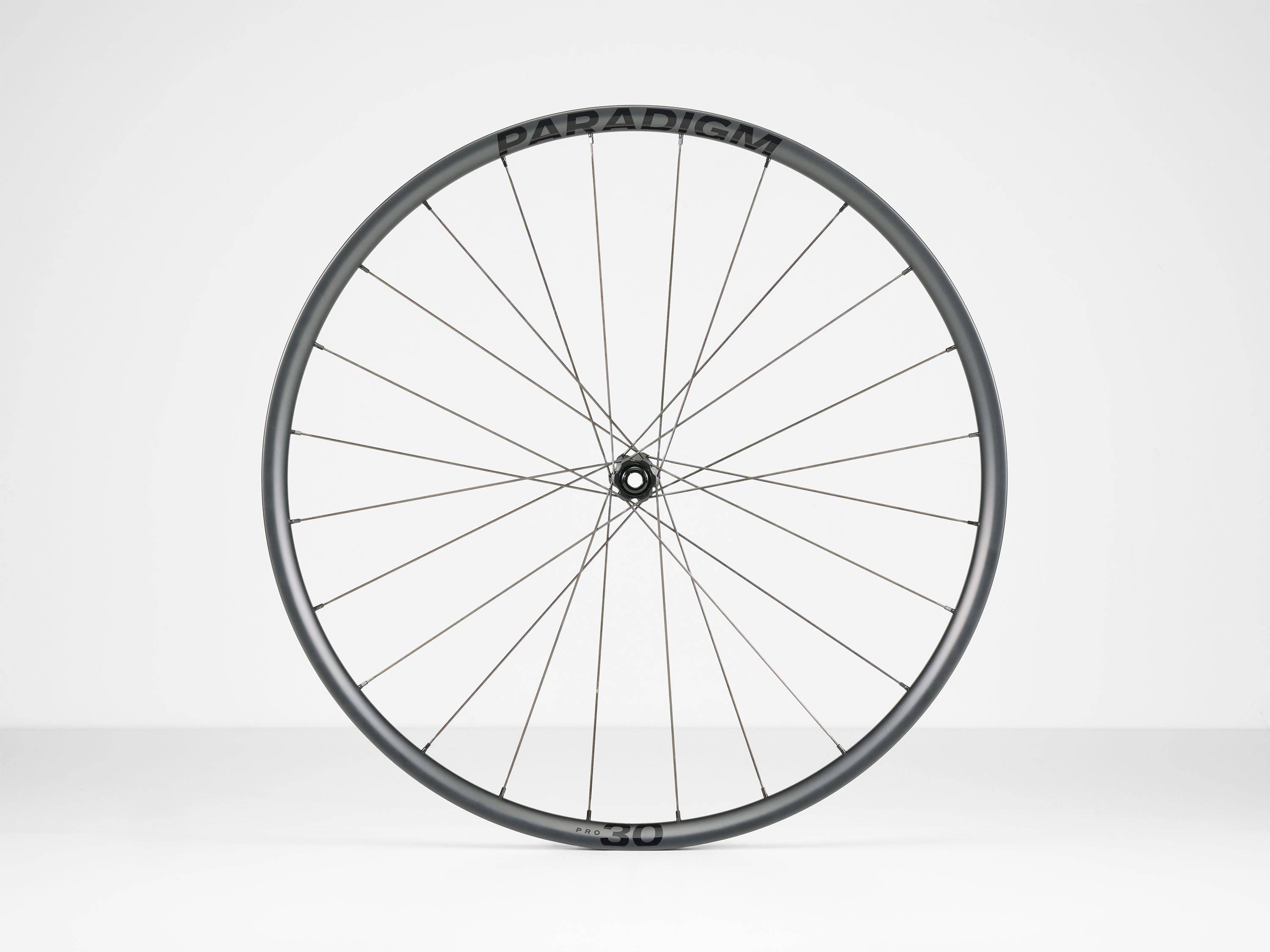 Bontrager Paradigm Pro 30 TLR disc road wheel with tubeless-ready, aerodynamic design, shown mounted on a bicycle.
