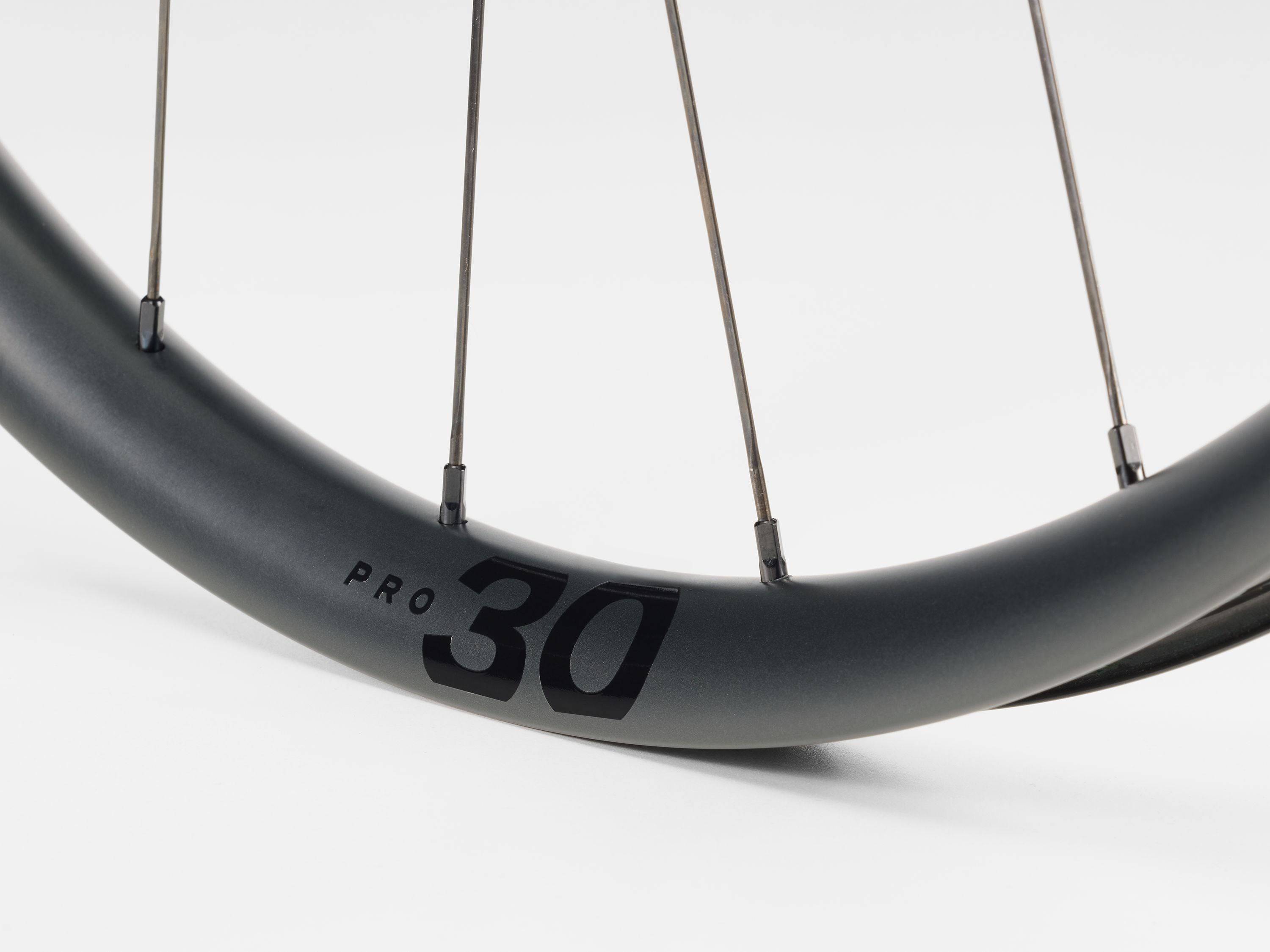 Bontrager Paradigm Pro 30 TLR disc road wheel with tubeless-ready, aerodynamic design, shown mounted on a bicycle.