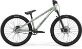 Green Merida Dirt 700 MY26 kids' dirt jump bike with RockShox Pike DJ fork and SRAM brakes, front view showing bike frame and suspension.