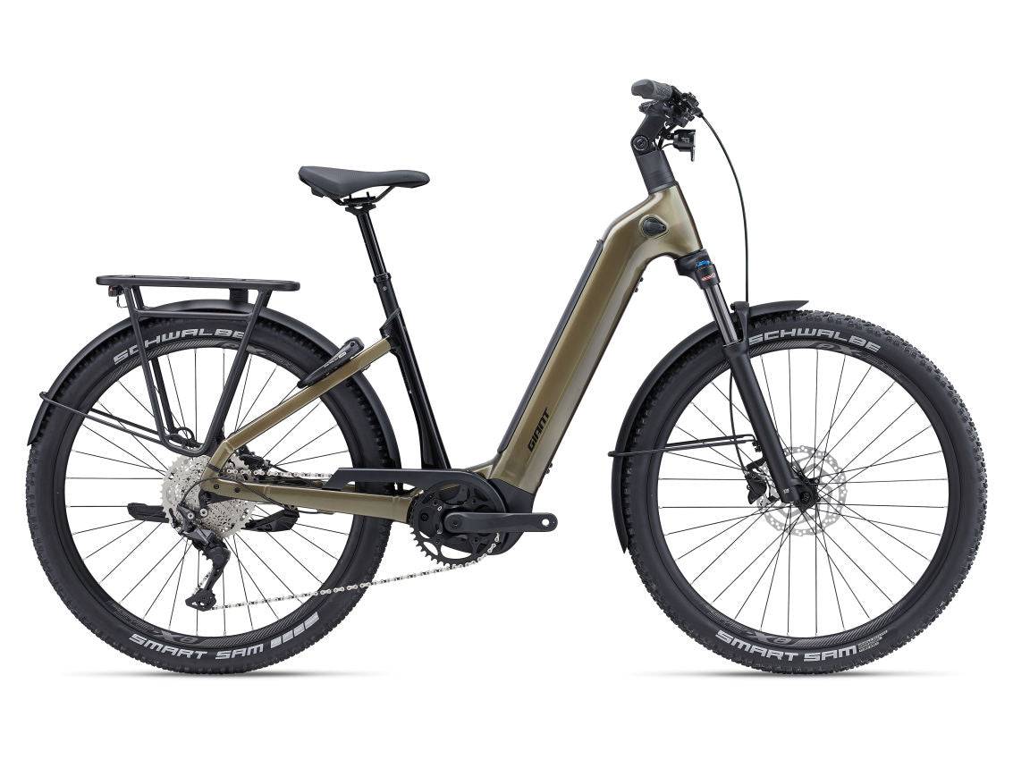 Liv AnyTour X E+ 3 2025 electric hybrid bike for women in Pyrite Brown, featuring a sleek frame and urban commuter design.