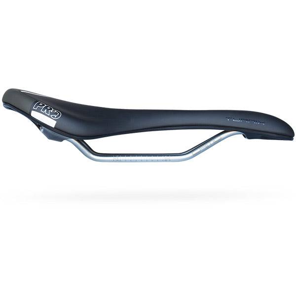 PRO Turnix Crmo saddle with PU padding and nylon fiber base, designed for comfort, shown in a close-up of the bike component.