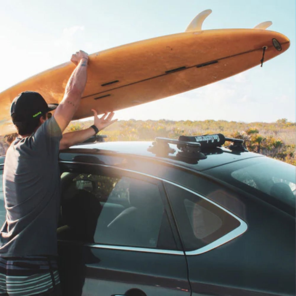 SeaSucker board rack with vacuum mounts installed on a car, designed for surfboards and paddle boards, close-up view.