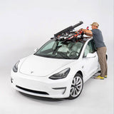 SeaSucker Classic Ski Rack vacuum mount holding four sets of skis and snowboards, mounted on a vehicle for outdoor winter sports.