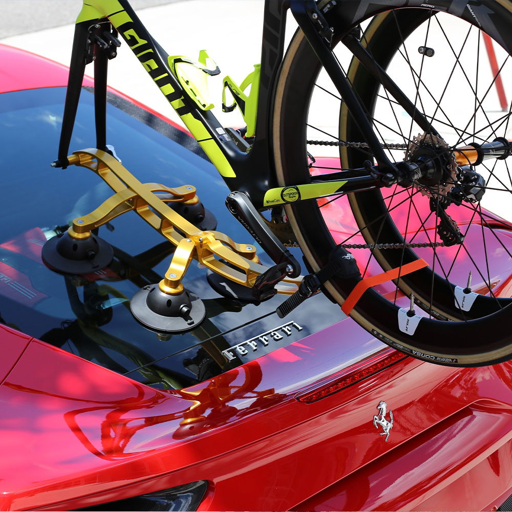 SeaSucker Komodo 1 Bike Rack mounted on sports car roof, compact design, securely holding a bicycle for convertible and sports car travel.