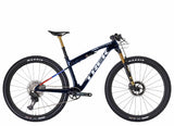 Trek Supercaliber SLR 9.9 XTR Di2 mountain bike with IsoStrut rear suspension, shown in a sleek black and red design.