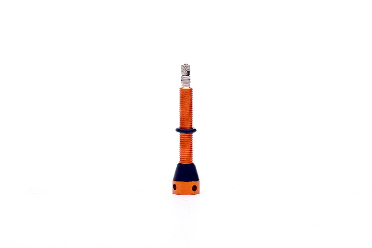 Orange FBI 45mm tubeless valve for secure, airtight seal on tubeless tires, component designed for reliable tire inflation.