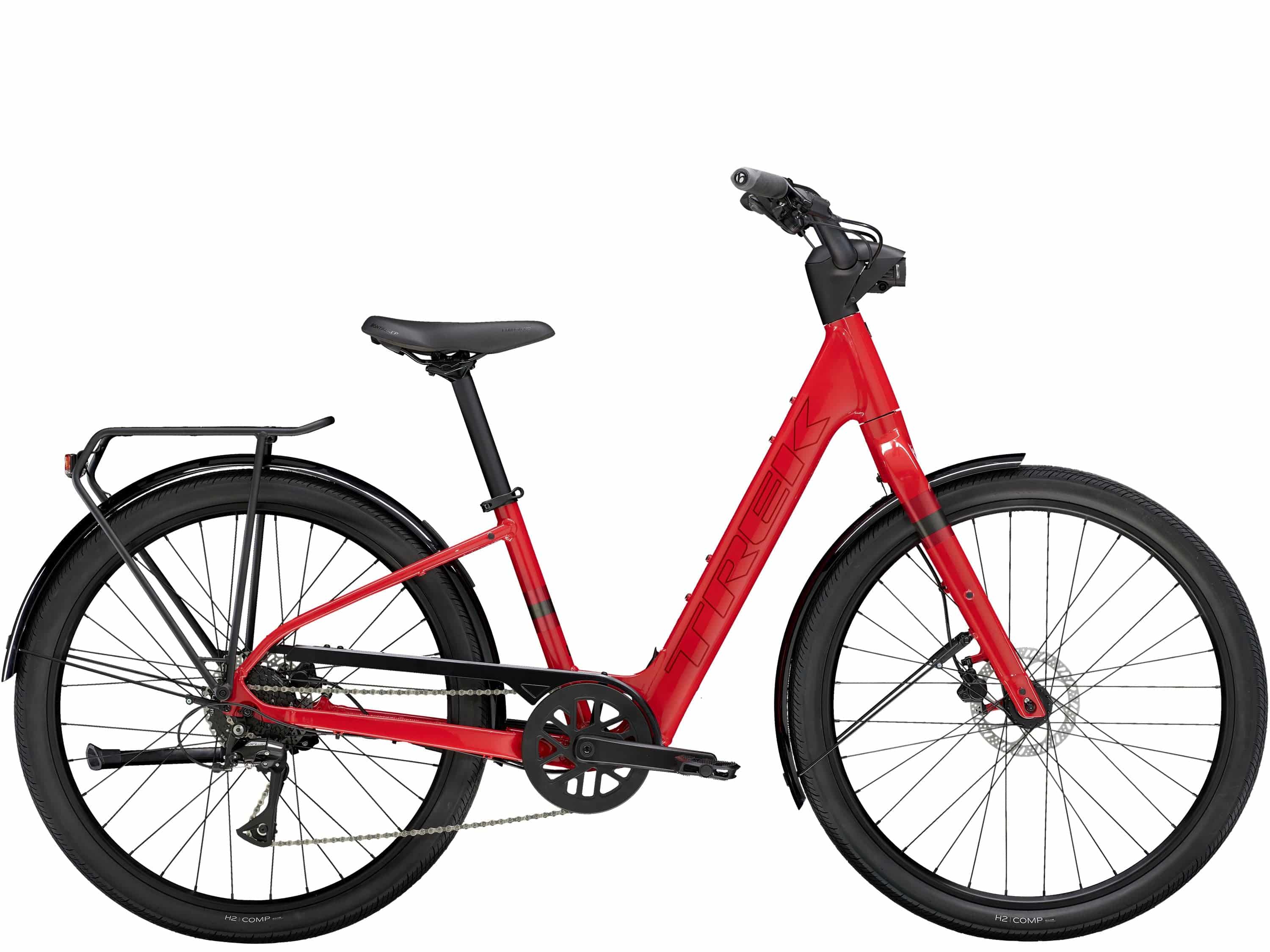 Trek Verve+ 1 Lowstep LT women's electric hybrid bike with step-through frame, shown in a city setting with bike components visible.